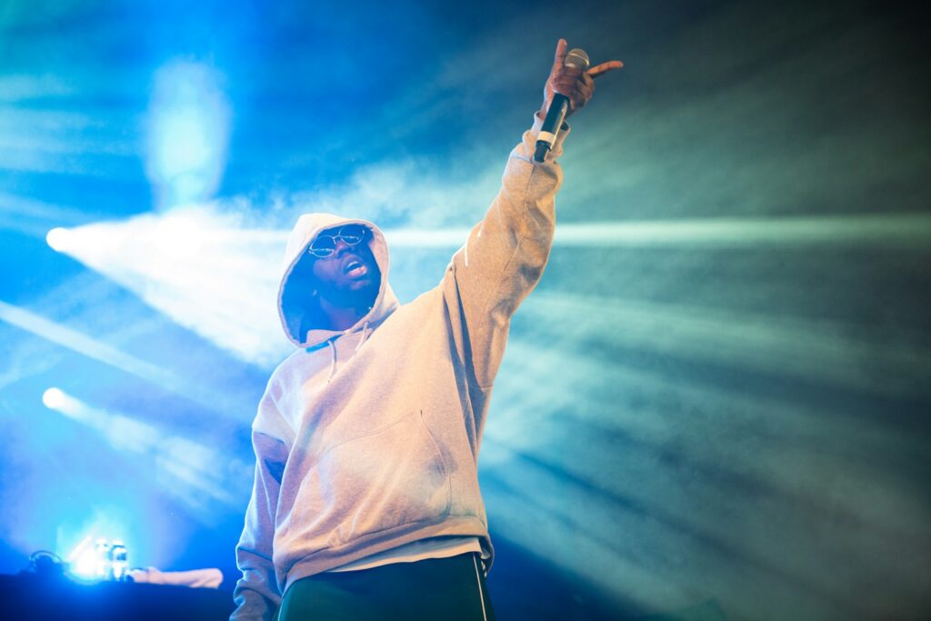 man raising his left hand with microphone